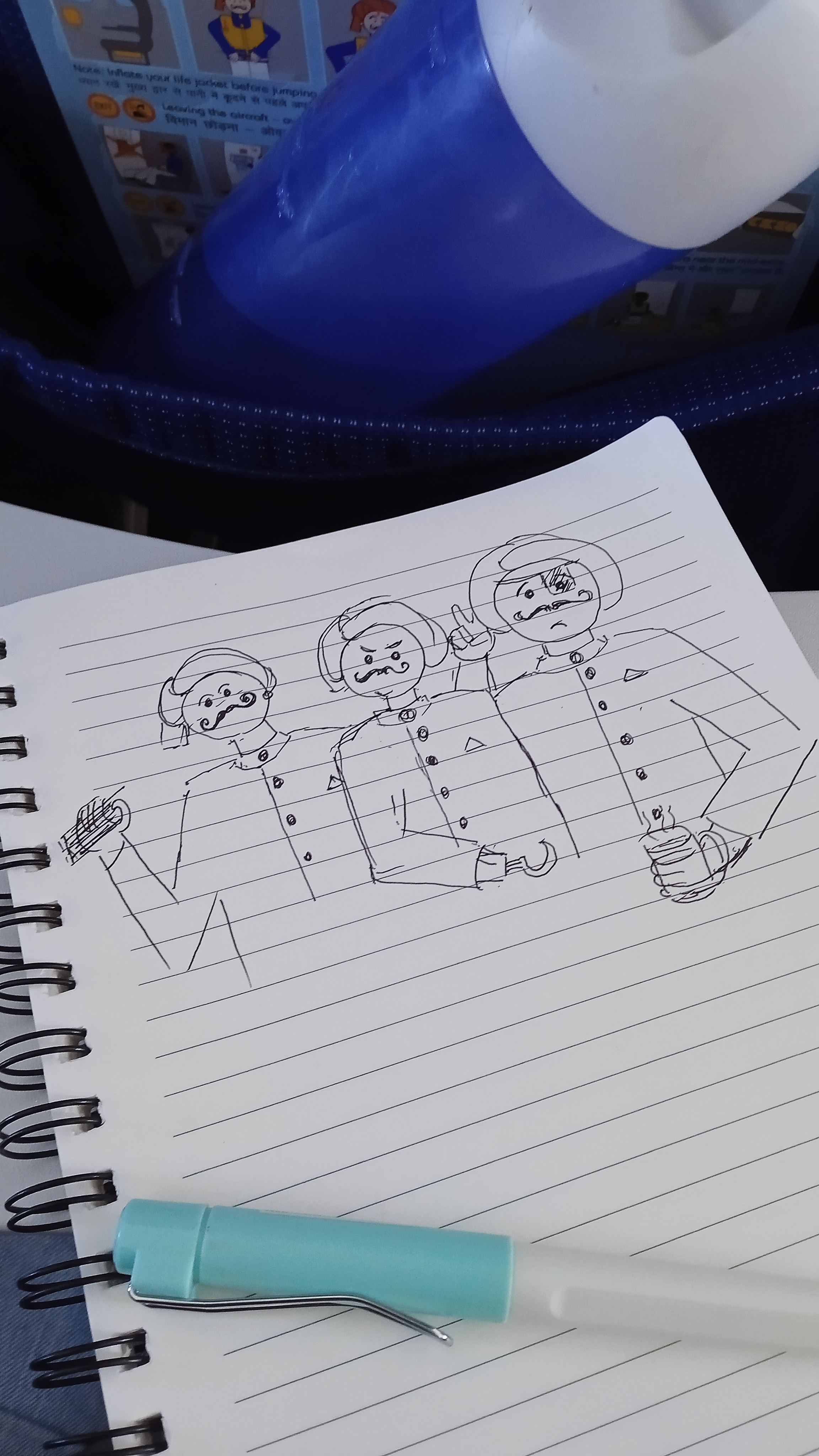 Drawing on a notebook featuring three people, one with a walkie-talkie, one with hook-hands, and one with a cup of beverage and an eyepatch.