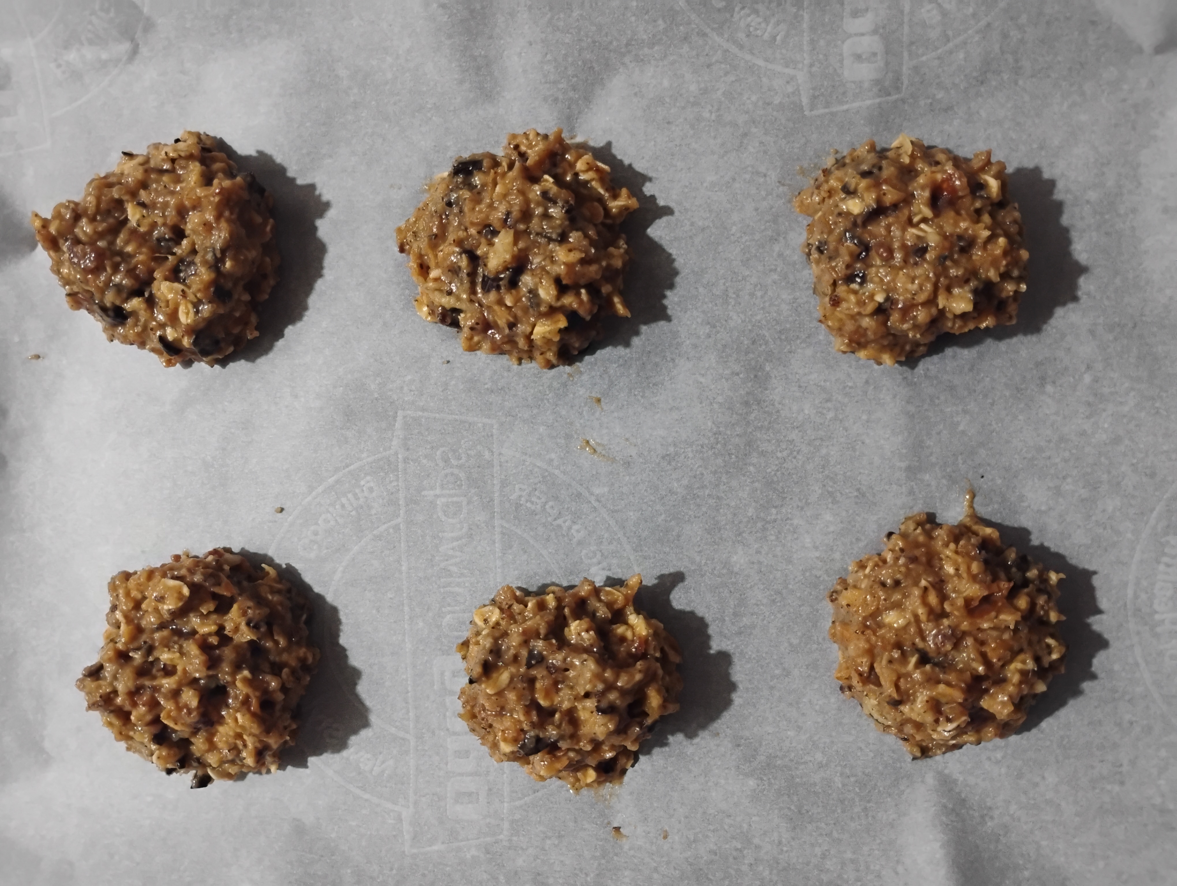 6 dollops of cookie dough on a baking tray lined with baking sheets